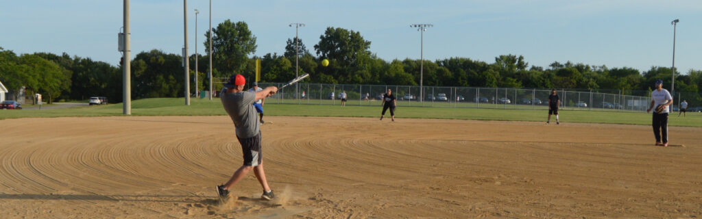 Softball game hitting the ball